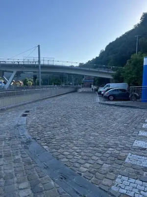a parking lot with cars and a bridge in the background at Bel appart - Tilff in Tilff