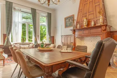 a dining room with a wooden table and chairs at 12P 6B Renovated villa with jacuzzi at Genk in Genk