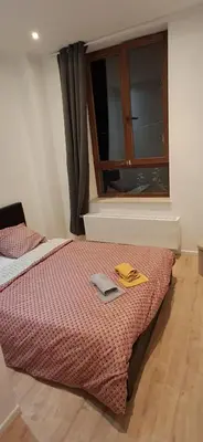 a bedroom with a bed with a window and a book at Appartement dans rue calme in Liège