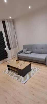 a living room with a couch and a coffee table at Appartement dans rue calme in Liège