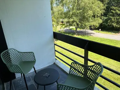 a balcony with two chairs and a table and a window at Appart de Lux , 3 borders , free parking , in La Calamine