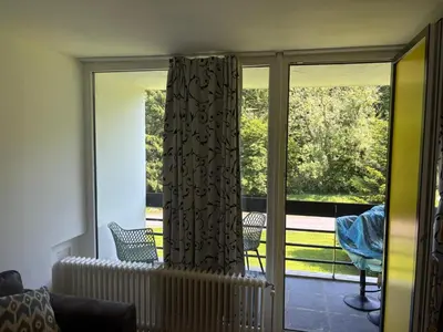 a screened in porch with a curtain and chairs at Appart de Lux , 3 borders , free parking , in La Calamine