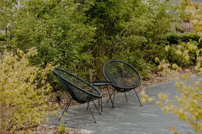 two benches sitting next to each other in a garden at Hangar C gastensuites in Heers