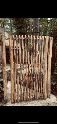 a wooden fence in front of a tree at Five Trees Forest Home in Lanaken
