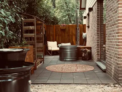 a patio with a table and a chair and a fence at Five Trees Forest Home in Lanaken