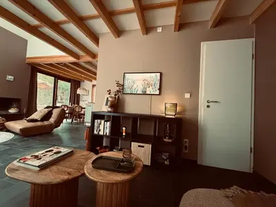 a living room with two tables and a couch at Five Trees Forest Home in Lanaken