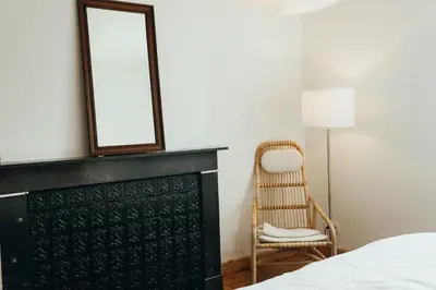a bedroom with a black fireplace and a chair at Simonis, Parc de la Boverie by WelcHome in Liège