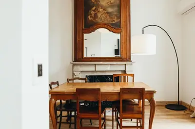 a dining room with a table and a mirror at Simonis, Parc de la Boverie by WelcHome in Liège