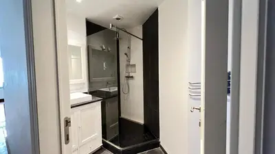 a white bathroom with a sink and a shower at 102 Cozy Neuvice in Liège