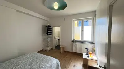 a white bedroom with a bed and a window at 201 Loft Lumineux en Hyper-Centre in Liège