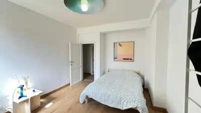 a bedroom with a bed and a white wall at 201 Loft Lumineux en Hyper-Centre in Liège