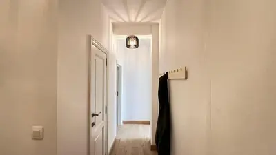a hallway with a white door and a light fixture at 301 Loft Chic Central in Liège