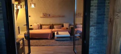 a living room with a couch and a mirror at Vacation on the farm in Lanaken