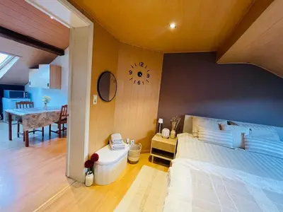 a bedroom with a bed and a clock on the wall at Appartement rustique à Liège in Liège