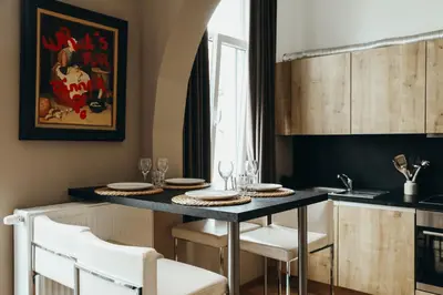 a kitchen with a table with white chairs and a tableablish at Liège Centre-ville by WelcHome in Liège