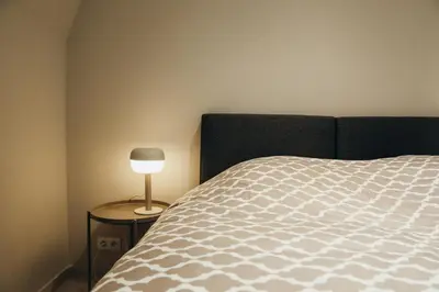 a bedroom with a bed and a lamp on a table at Liège Carré by WelcHome in Liège