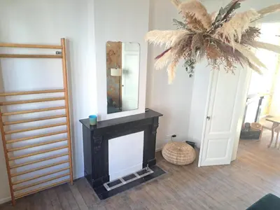 a living room with a fireplace and a mirror at Chambre luxe in Liège