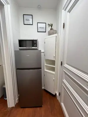 a kitchen with a refrigerator and a microwave at home sweet home in Liège