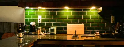 a kitchen with green tiles on the wall and a sink at Luxe loft in vierkantshoeve in Sint-Truiden