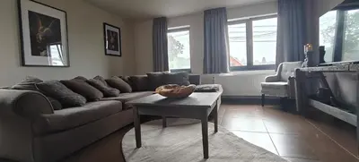 a living room with a couch and a table at Het Mezennest in Zonhoven