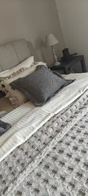 a bed with two pillows on it with a lamp on a table at Het Mezennest in Zonhoven