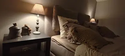 a bedroom with a bed and a table with a lamp at Het Mezennest in Zonhoven