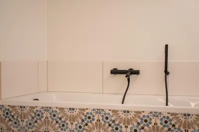 a bath tub with a faucet in a bathroom at Villa Weidezicht in Heusden - Zolder