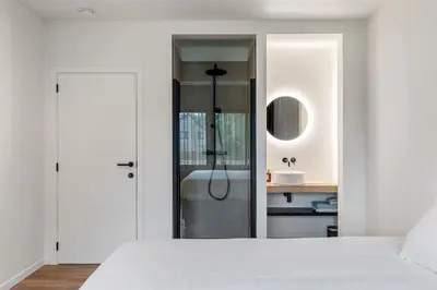 a white bedroom with a bed and a sink at Villa Weidezicht in Heusden - Zolder