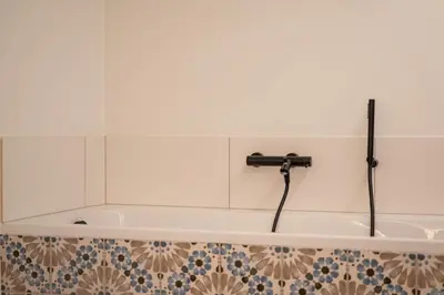 a bath tub with a faucet in a bathroom at Villa Weidezicht in Heusden - Zolder