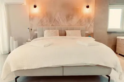 a bedroom with a large bed with a white comforter at La Suite Kalys in Thimister