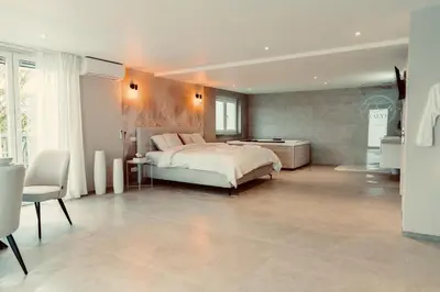 a bedroom with a bed and a table and a chair at La Suite Kalys in Thimister