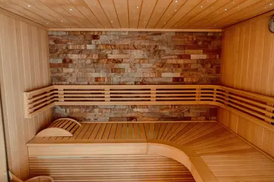 a sauna with wooden benches and a brick wall at La Suite Kalys in Thimister