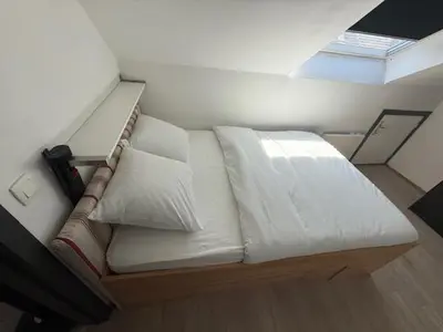 a bed with white sheets and pillows in a room at Melo in Plombières