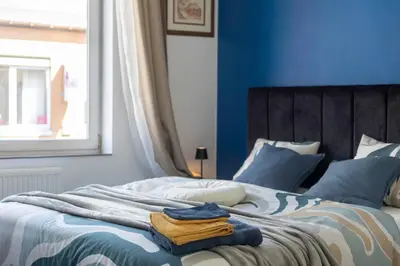 a blue bedroom with a bed with towels on it at Chambres de luxe SDB WC Privés in Liège