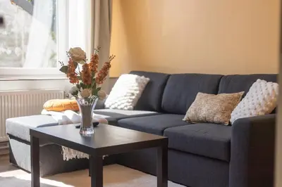 a living room with a blue couch and a table at Appartement de luxe Dubai , Chambre, salon et SDB Privés, cuisine partagée in Liège