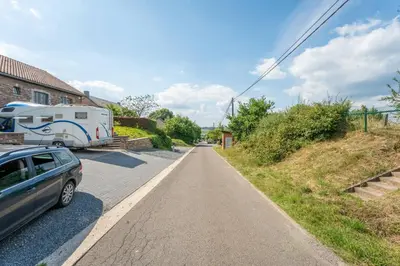 a road with a car parked next to a trailer at L étage in Soumagne