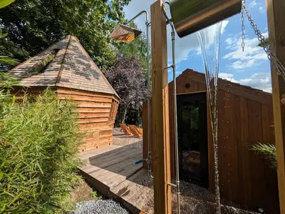 an open door to a wooden cabin with a deck at la pomme de pin Cornesse