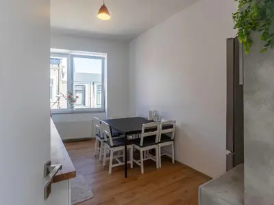 a kitchen and dining room with a table and chairs at Chambre de luxe MADRID a LIEGE Sale de bain privée 1er étage check in autonome cuisine partagée in Liège