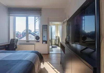 a hotel room with a bed and a flat screen tv at Chambre New York à Liège Moderne avec salle de bain privée spacieuse, check in autonome, 2eme etage in Liège