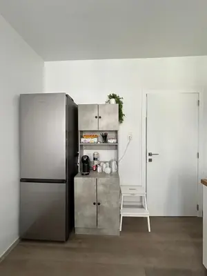 a kitchen with a stainless steel refrigerator and a chair at Chambre de luxe Afrik a Liège Grande Sale de bain privée check in autonome cuisine partagée in Liège