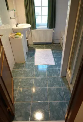 a bathroom with a blue tiled floor and a sink at Le Grand Jardin in Dalhem