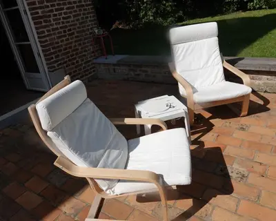 two white chairs sitting on a brick patio at Le Grand Jardin in Dalhem