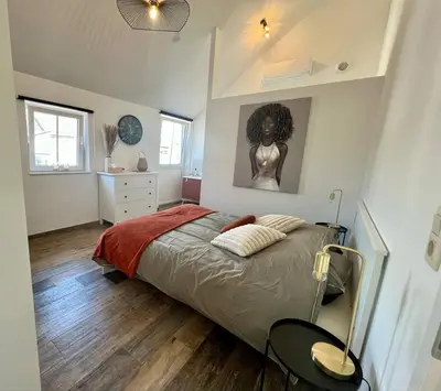 a bedroom with a bed and a picture of a woman at La maison de MiLy in Bassenge