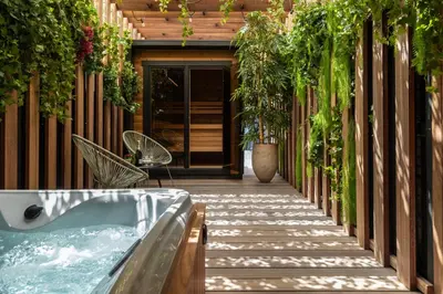 a hot tub on the side of a building with plants at Suite Escape in Hasselt