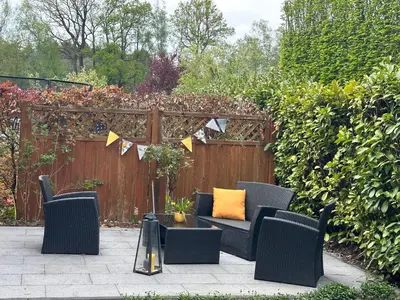 a patio with chairs and a table and a fence at Johannisbeere in Raeren
