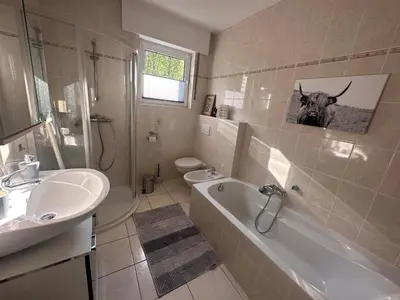 a bathroom with a sink and a tub and a toilet at Johannisbeere in Raeren