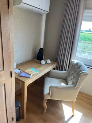 a desk with a chair next to a window at 't Steenenhuys in Dilsen-Stokkem
