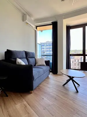 a living room with a blue couch and a table at Cozy and fully equipped in the center of Liege 4 guests in Liège