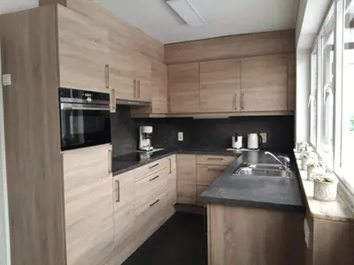 a kitchen with wooden cabinets and a sink at Casa Sahara - 8 guests - near nature reserve in Lommel