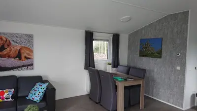a living room with a couch and a table at Camping Natuurlijk Limburg - Chalet 4 in Voeren